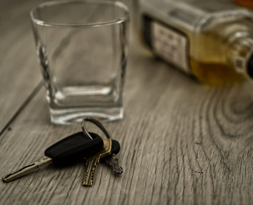Стакан, бутылка и ключи на столе