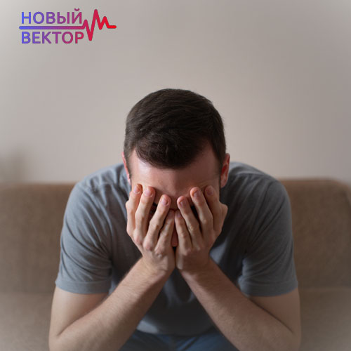 Мужчина сидит и держится за голову