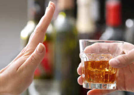 Протянутая рука со стаканом алкоголя и жест отказа