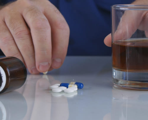 Стакан с алкоголем и таблетки